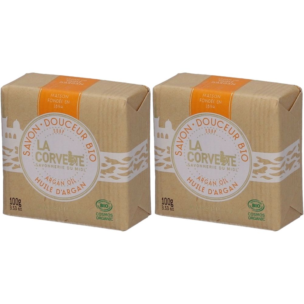 Deux savons emballés dans du papier. Inscription : LA CORVETTE, huile d'argan, BIO. 100g. Avec bande blanche et bande orange.