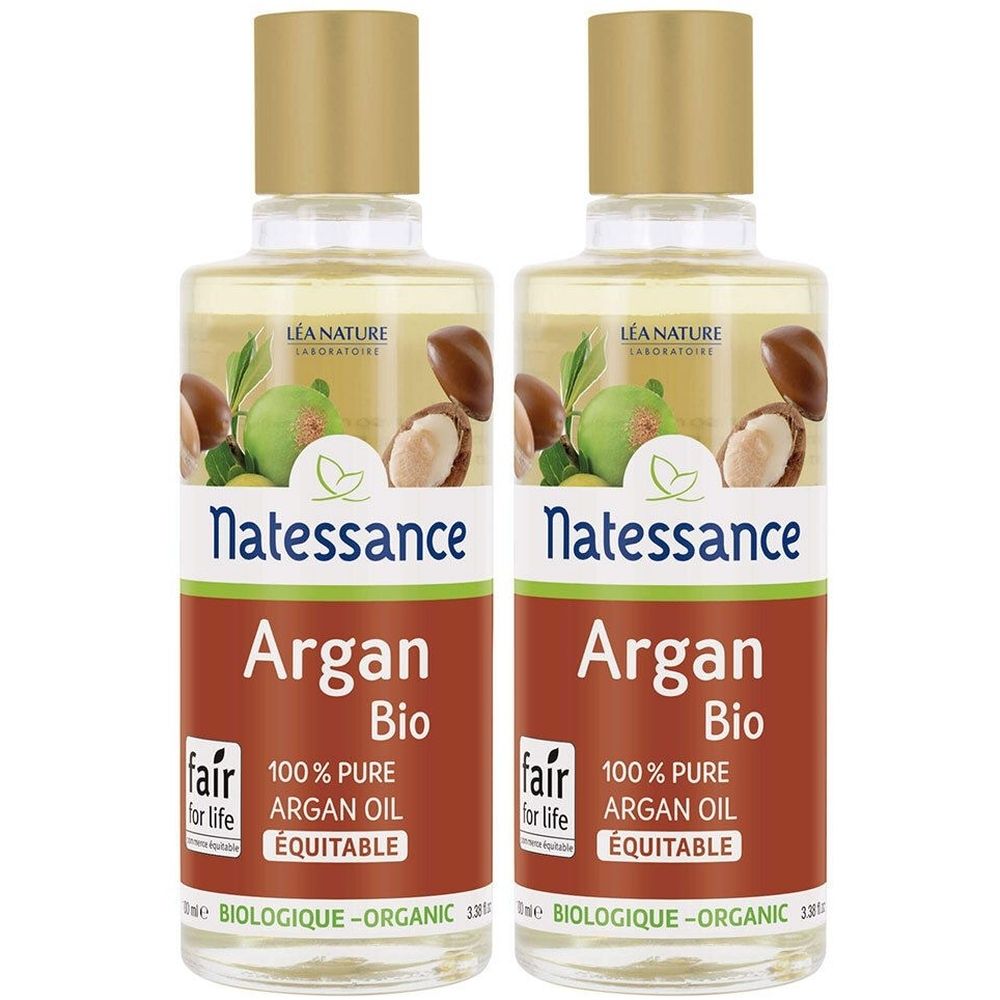 Twee flessen met gouden doppen. Labels: "Natessance Argan Bio 100% Pure Argan Oil". Logo met arganvruchten.