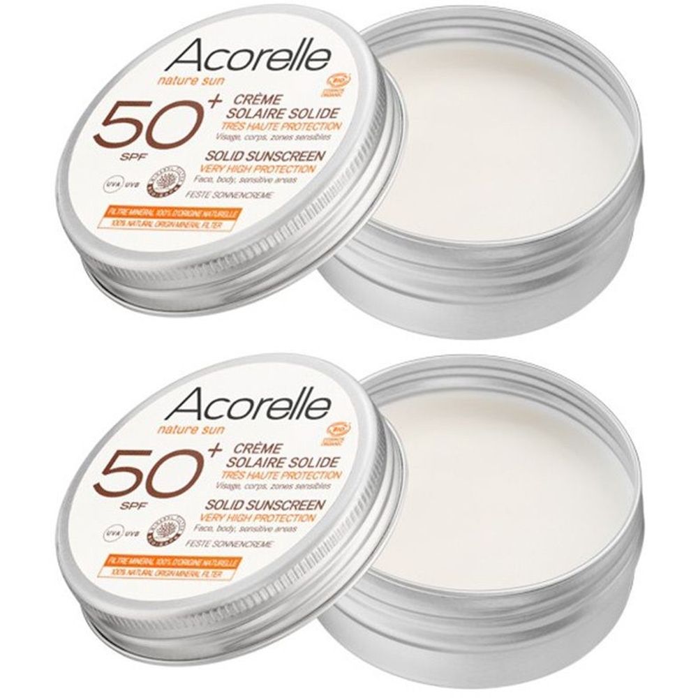 Deux boîtes rondes argentées de crème solaire. Couvercles avec texte: Acorelle, 50 SPF, Crème Solaire Solide. Logo de certification.