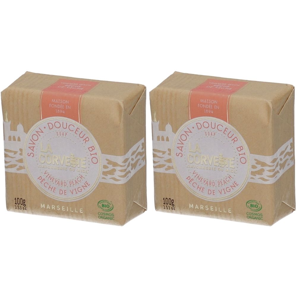 Twee vierkante zeepjes verpakt in papier. Opschrift: Savon Douceur Bio, Pêche de Vigne, Marseille. Met bio-certificering.