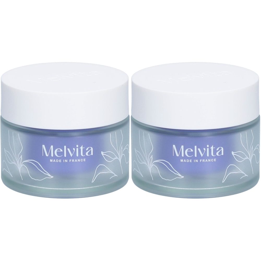 Deux pots avec couvercles blancs et verre bleu. Le nom "Melvita, Made in France" est visible sur le devant.