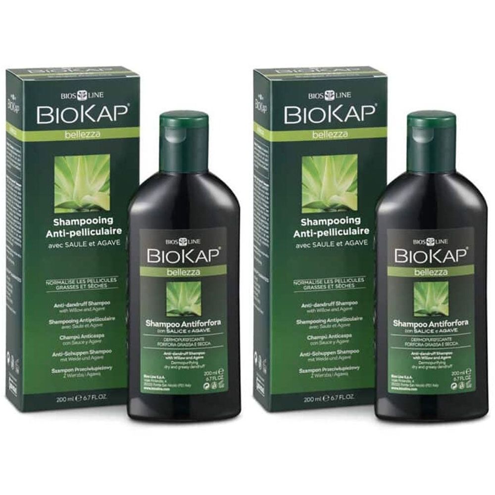Twee flessen en twee dozen BIOKAP shampoo. Zwarte flessen met groene doppen. Groene dozen met productinformatie.