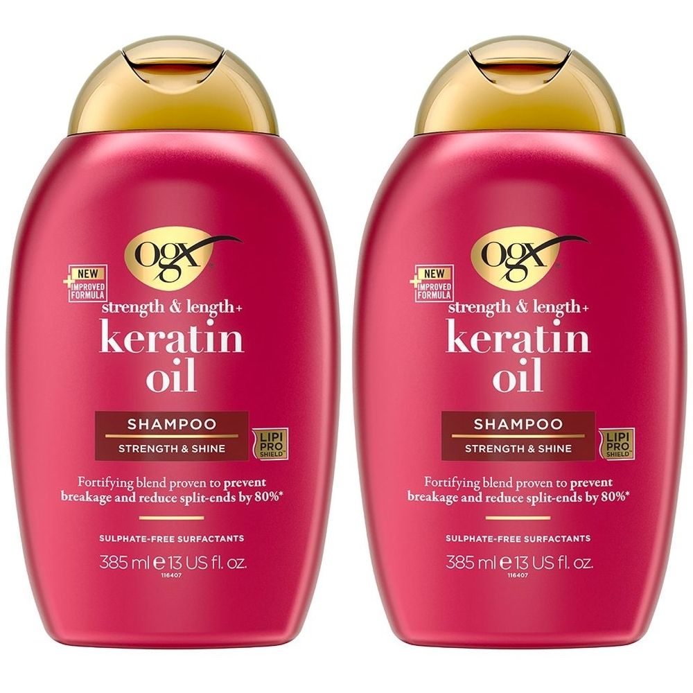 Twee shampoo flessen. Rode flessen met gouden dop. Opschrift: OGX Keratin Oil Shampoo. Sterkte & glans. Voorkomt haarbreuk.
