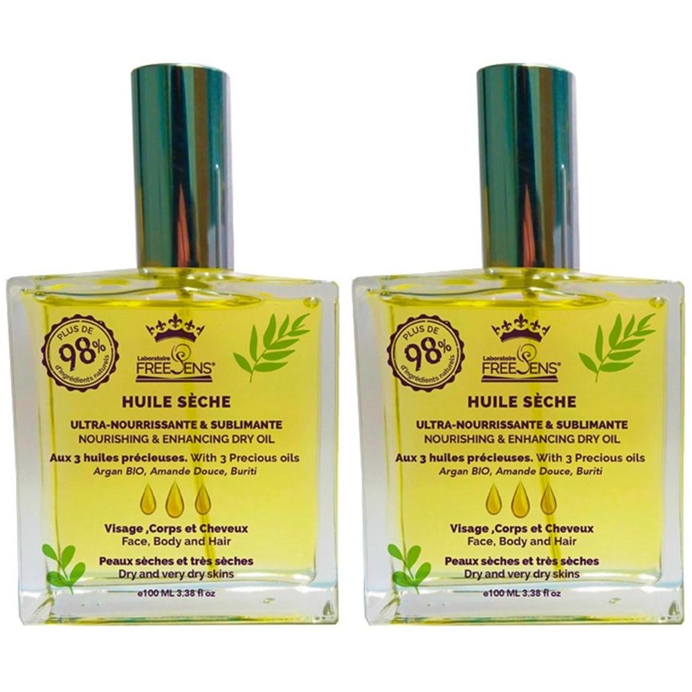 Twee vierkante glazen flessen met gele olie. Opschrift: Huile Sèche, Ultra-Nourrissante & Sublimante. Met 3 oliën. Voor droge huid.