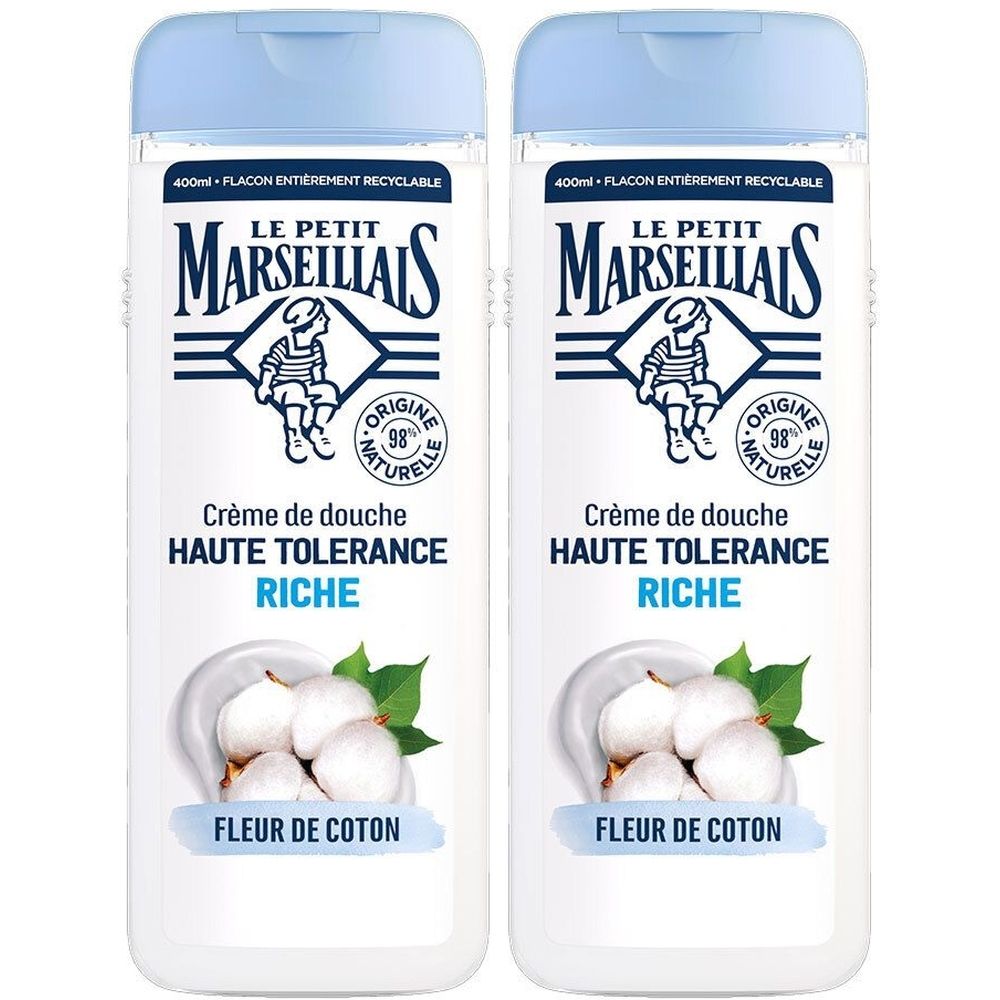 Deux flacons de crème de douche. Inscription: Le Petit Marseillais, Crème de douche Haute Tolérance Riche Fleur de Coton. Illustration de fleurs de coton.
