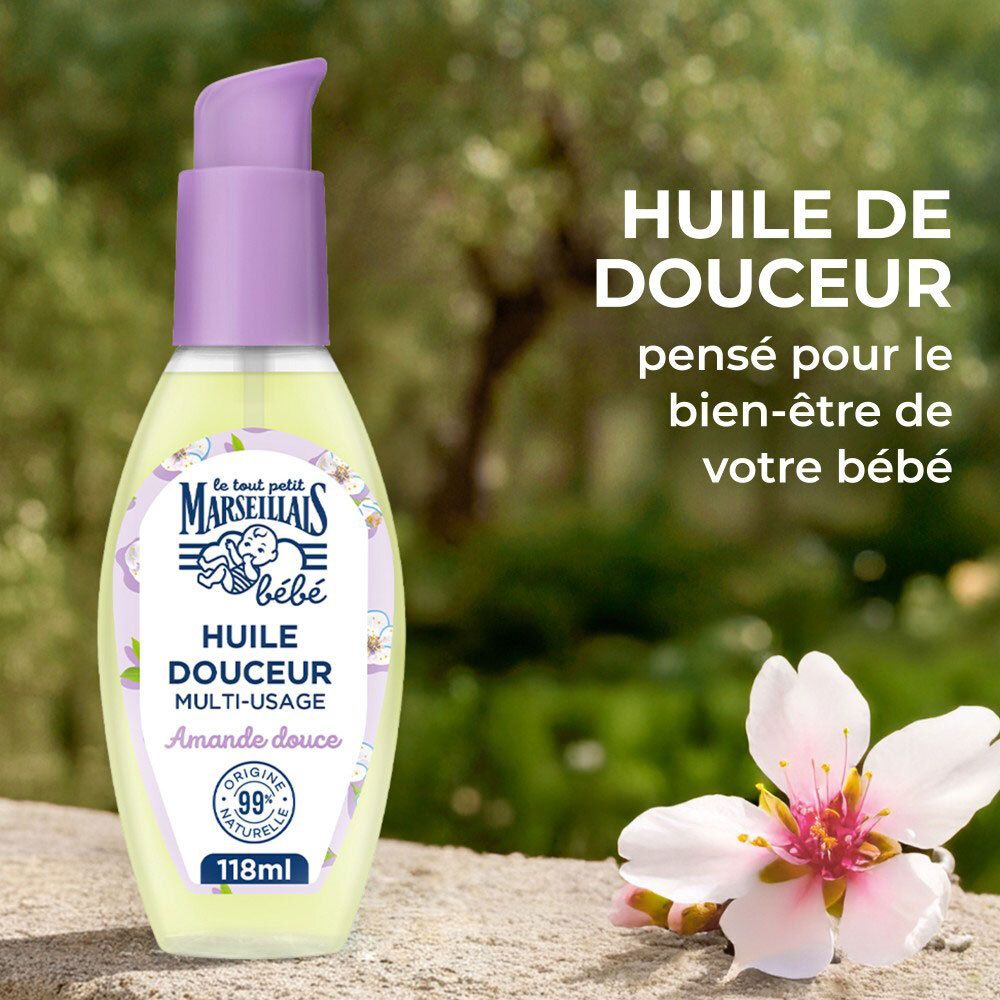 Flacon pompe, huile d'amande douce pour bébé, à côté d'une fleur d'amandier.