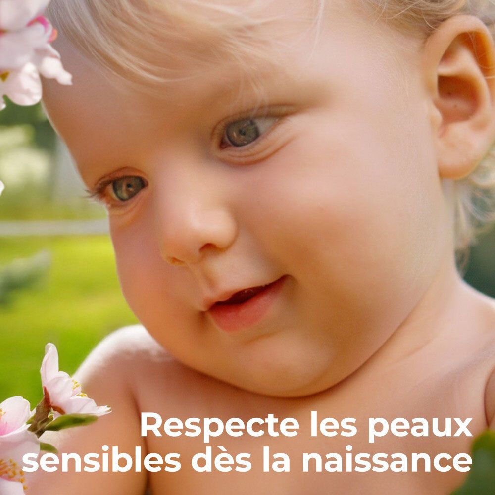 Gros plan d'un bébé à la peau douce, entouré de fleurs d'amandier.