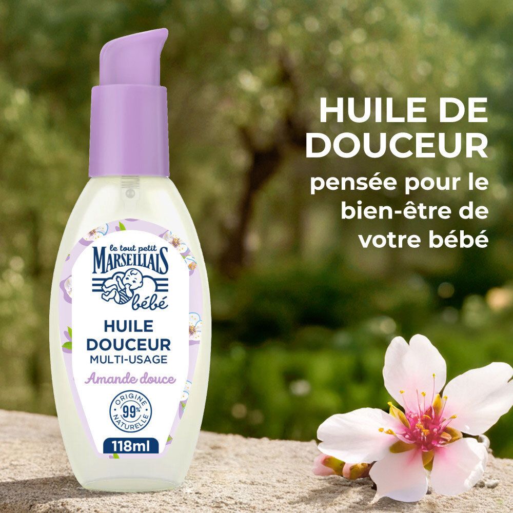 Flacon pompe, huile d'amande douce pour bébé, à côté d'une fleur d'amandier.