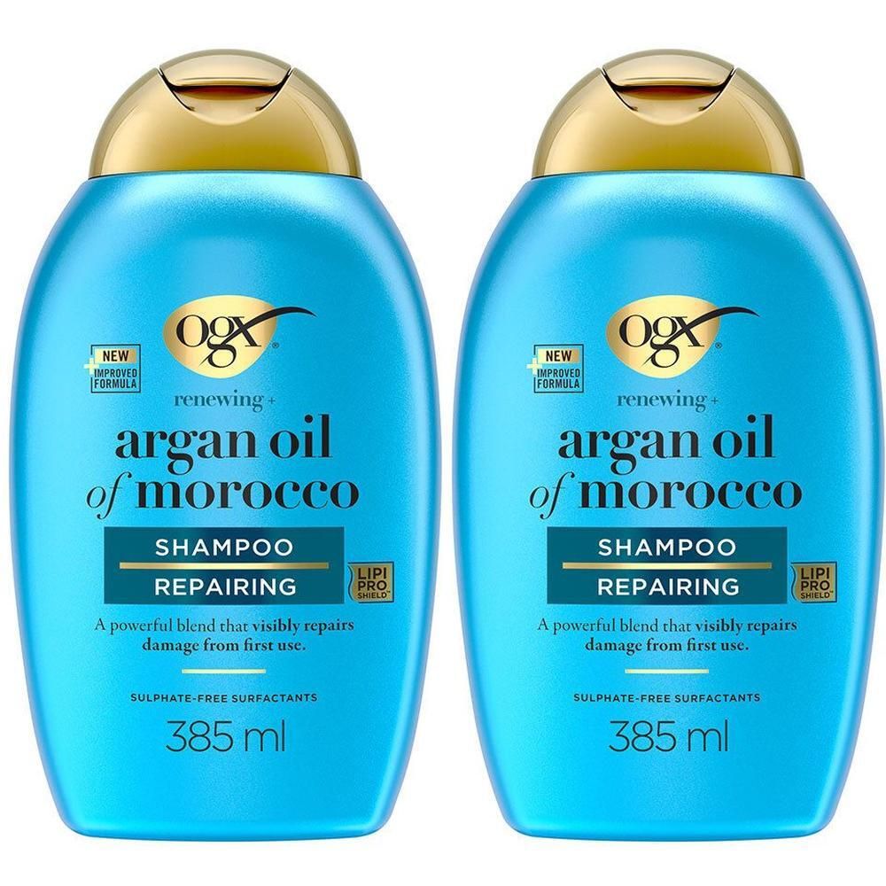 Twee blauwe shampoo flessen met gouden doppen. Opschrift: "OGX argan oil of morocco SHAMPOO REPAIRING". 385 ml.