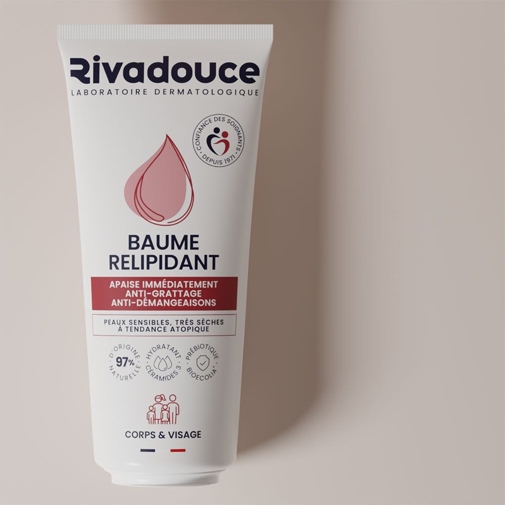 Witte tube met Rivadouce-logo en productnaam. Roze druppelsymbool. Tekst: Baume Relipidant, anti-jeuk, voor gevoelige, zeer droge huid.