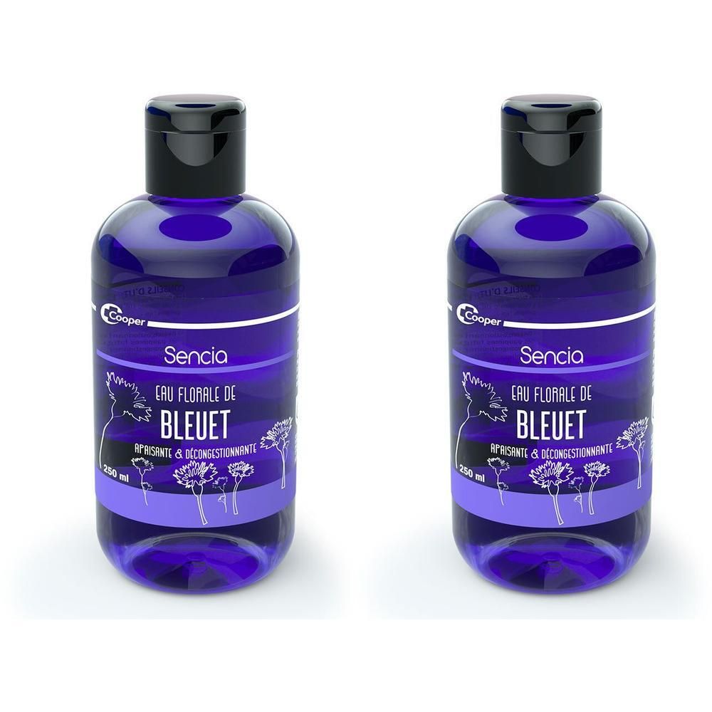 Twee blauwe flessen met zwarte dop. Opschrift: Sencia Eau Florale de Bleuet. Etiket met bloemenmotief.