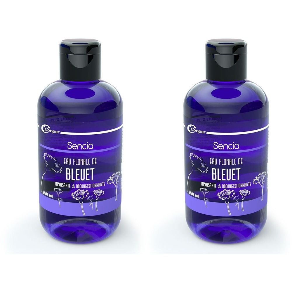Deux flacons bleus avec bouchons noirs. Inscription Sencia Eau Florale de Bleuet. Étiquette avec motif floral.