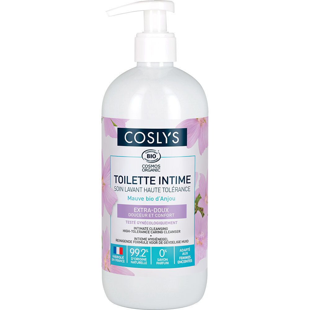 Witte fles met pomp. Label: Coslys, Toilette Intime, Extra-Doux. Bio-gecertificeerd, Franse vlag. Roze bloemen op de achtergrond.