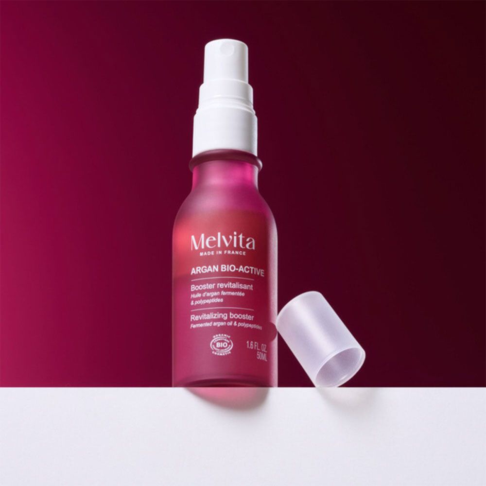 Rode fles met verstuiver en losse dop. Opschrift: Melvita Argan Bio-Active.