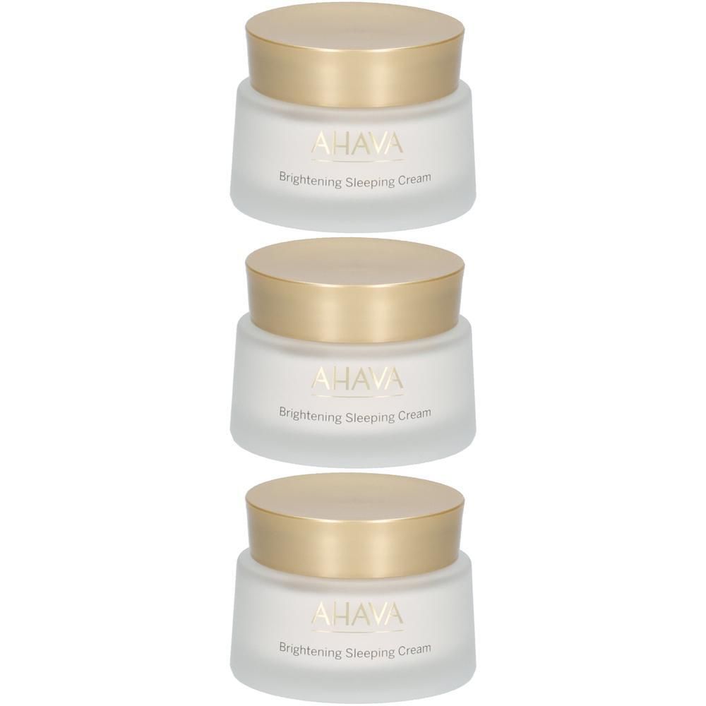 Trois pots de crème avec des couvercles dorés. AHAVA Brightening Sleeping Cream est écrit sur les pots.