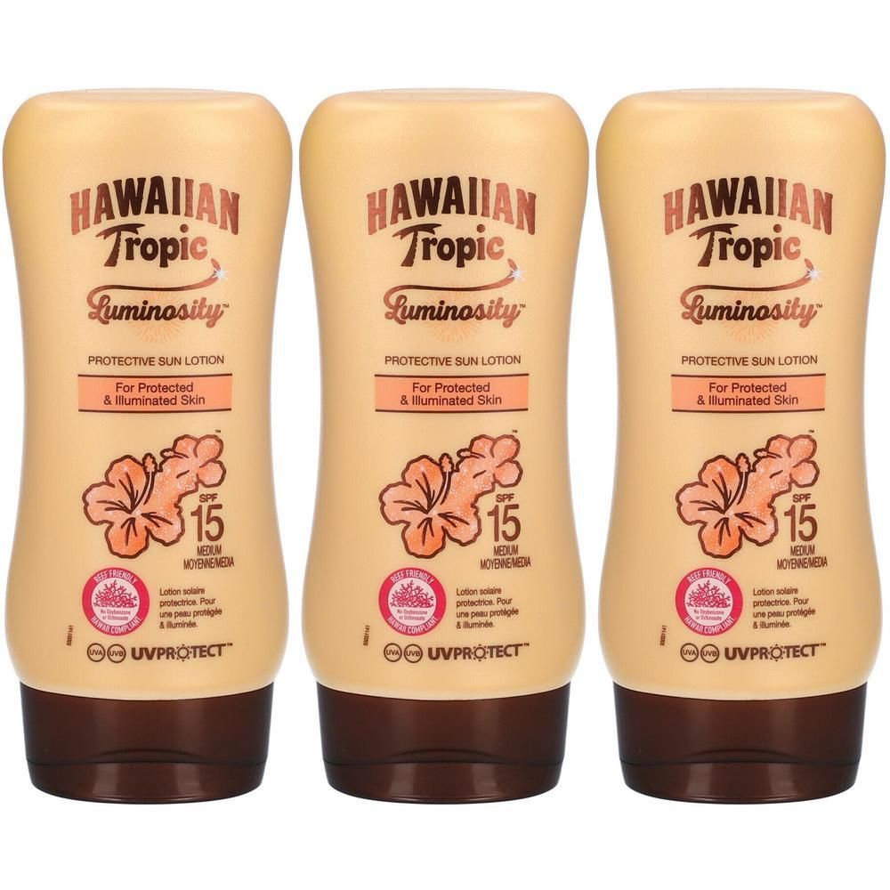 Trois flacons de lotion solaire Hawaiian Tropic Luminosity FPS 15 avec motif hibiscus.