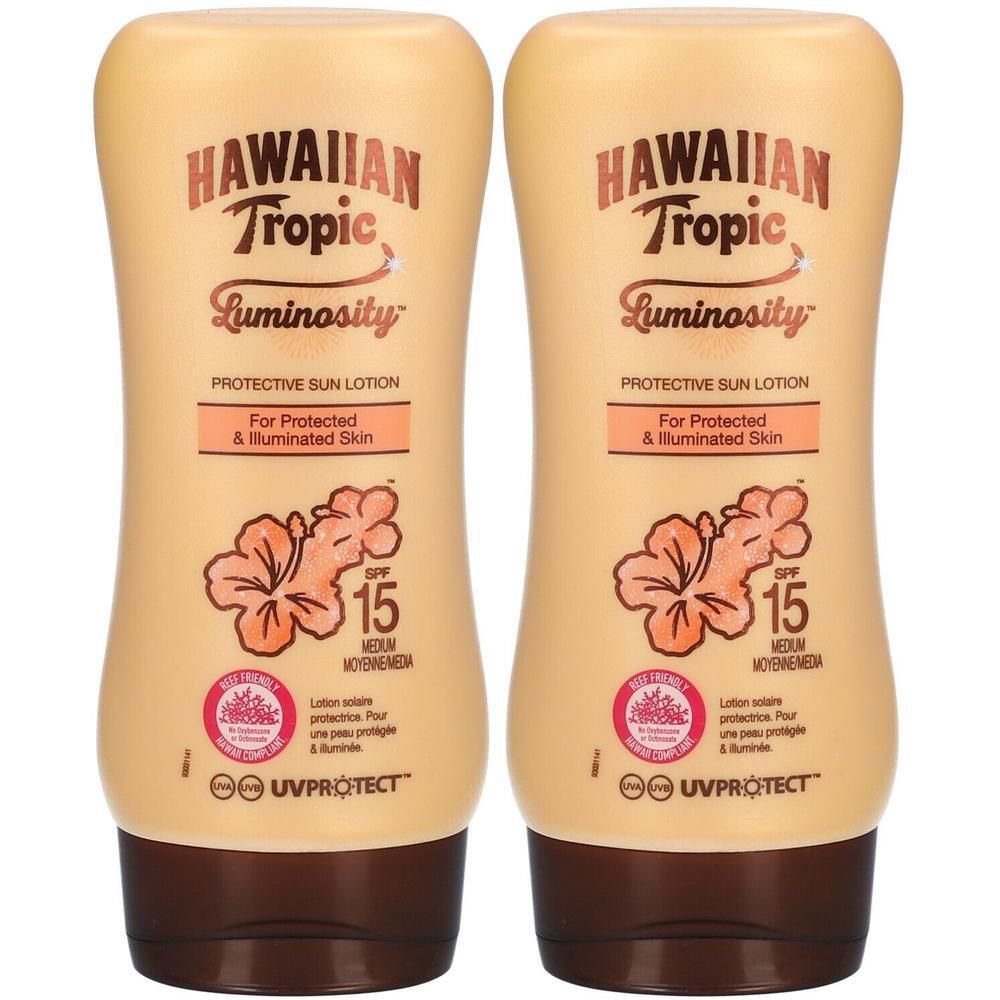 Deux flacons de lotion solaire Hawaiian Tropic Luminosity FPS 15 avec motif hibiscus.