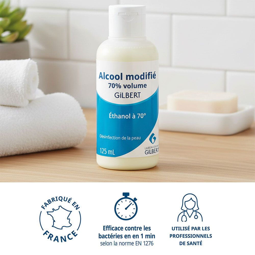 Flacon d'alcool, étiquette bleu et blanc, à côté de serviettes et savon. Certifications et logos.