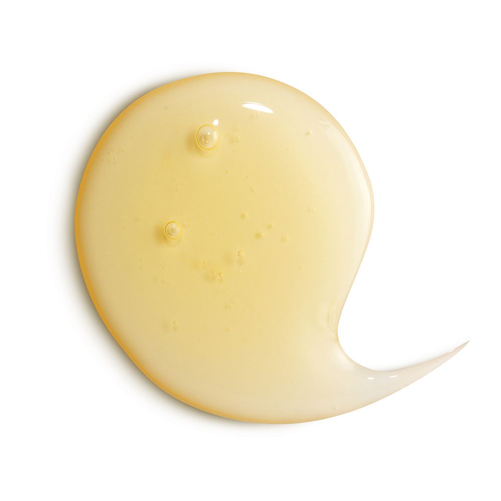Goutte de gel jaune et transparente avec des bulles d'air sur fond blanc.
