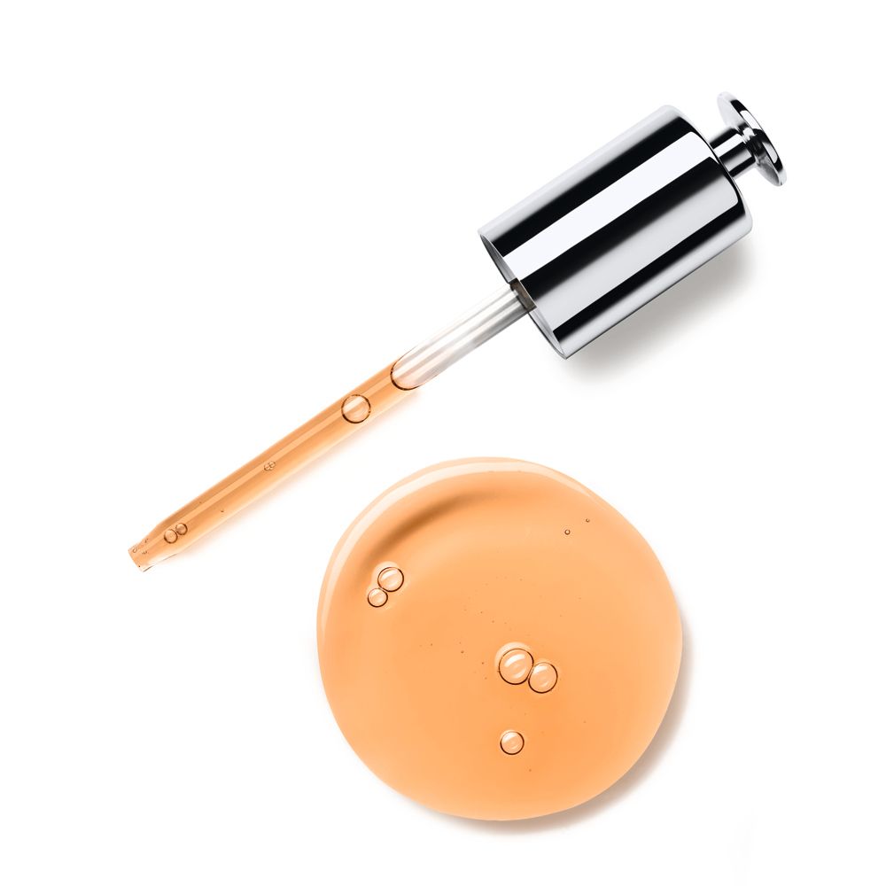 Pipet met serum en serumdruppel. Serum is amberkleurig. Op witte achtergrond.