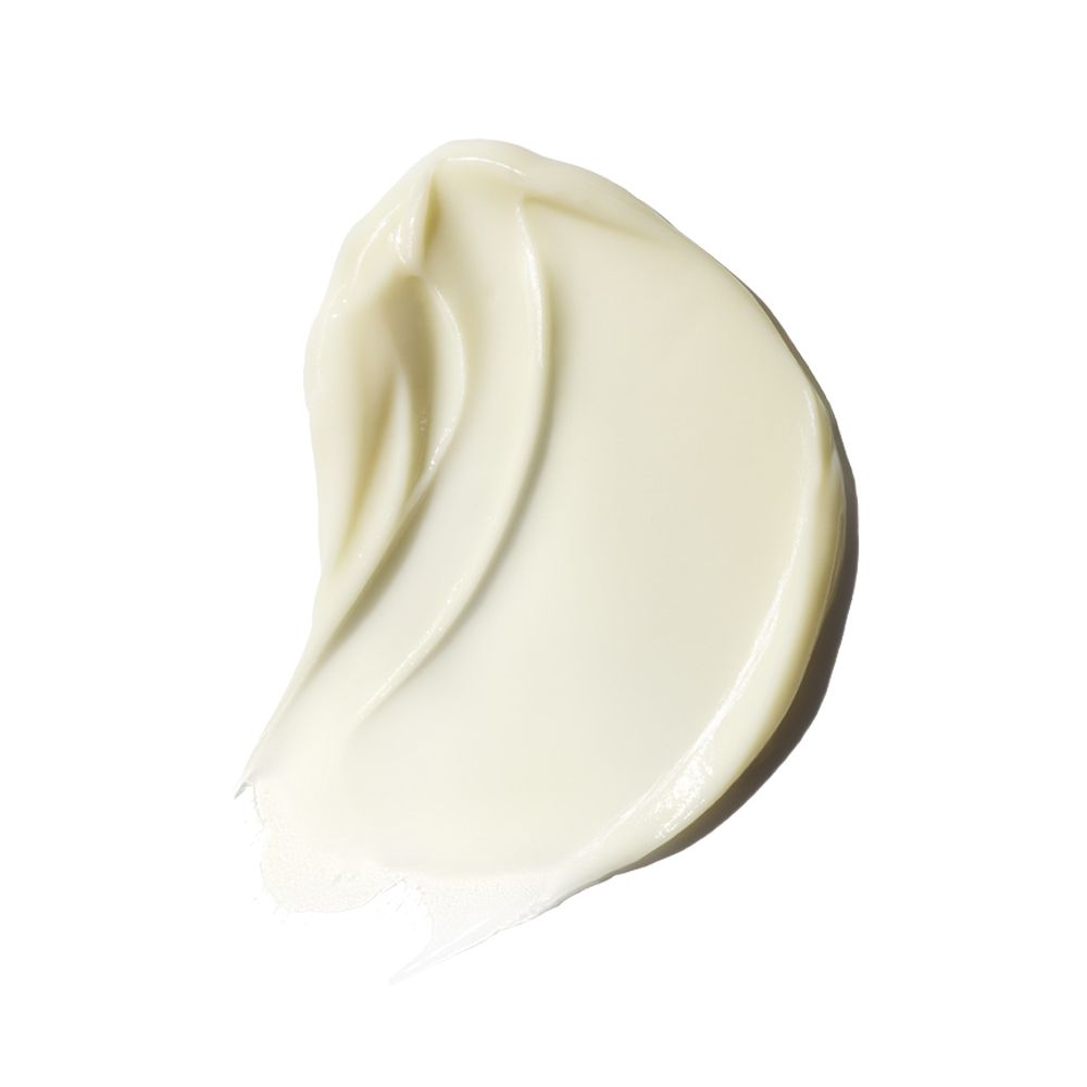 Gros plan sur une texture de crème. Trace ondulée de couleur crème sur fond blanc.