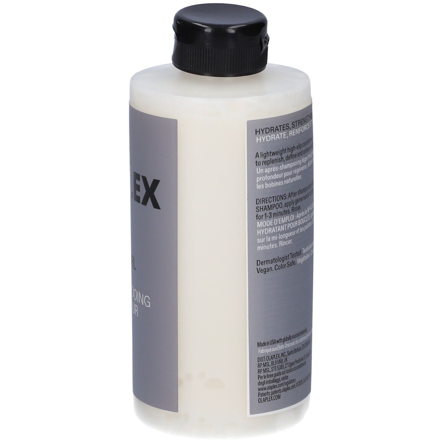 Bouteille blanche avec bouchon noir, étiquette avec texte.