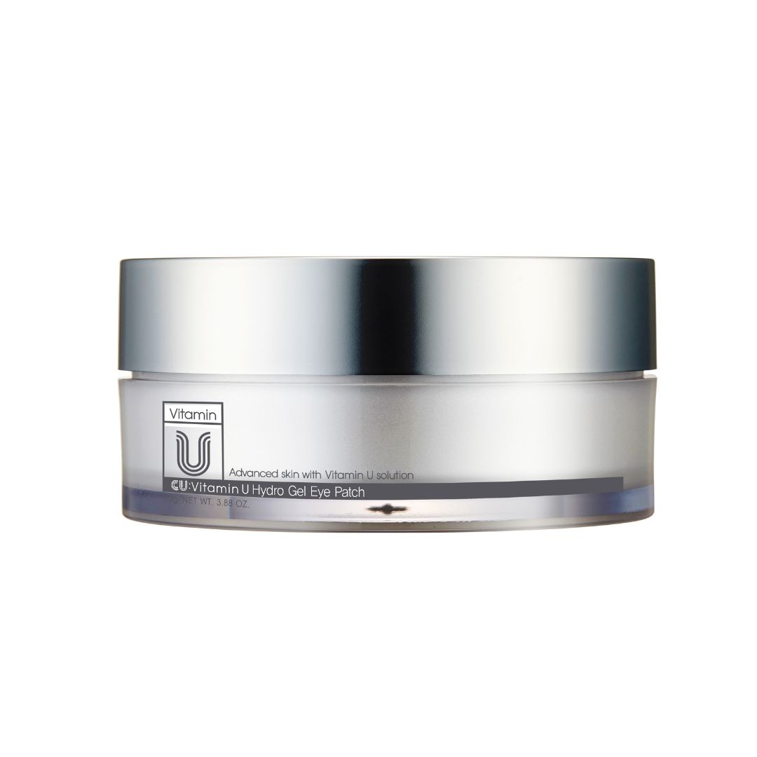 Boîte ronde argentée avec couvercle. Sur le devant, "Vitamin U" et "CU Vitamin U Hydro Gel Eye Patch" sont inscrits.