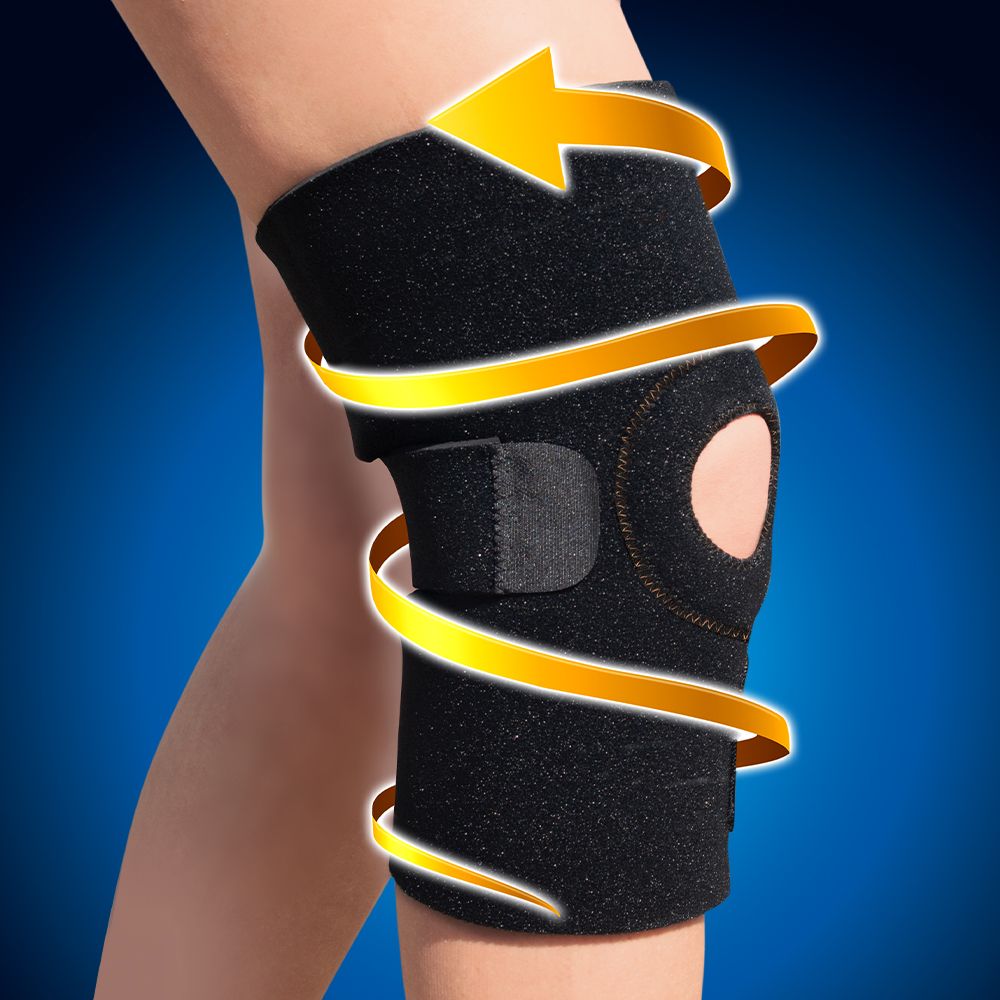 Koperen kniebrace gedragen op de knie. Zwart materiaal, gele pijlen tonen de wikkelrichting. Huidkleurige knieschijf zichtbaar.