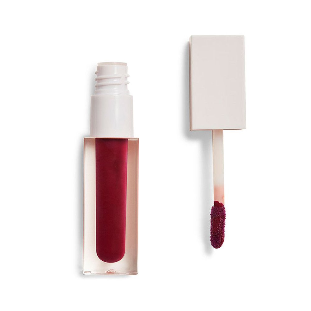 Flacon de gloss transparent avec contenu rouge. Le bouchon et l'applicateur sont à côté. L'applicateur a une pointe rouge.