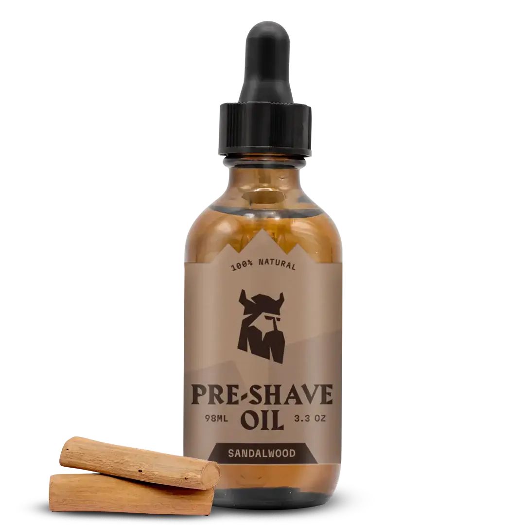 Flacon en verre brun avec compte-gouttes noir. Inscription : Pre-Shave Oil, Sandalwood. Deux morceaux de bois devant.