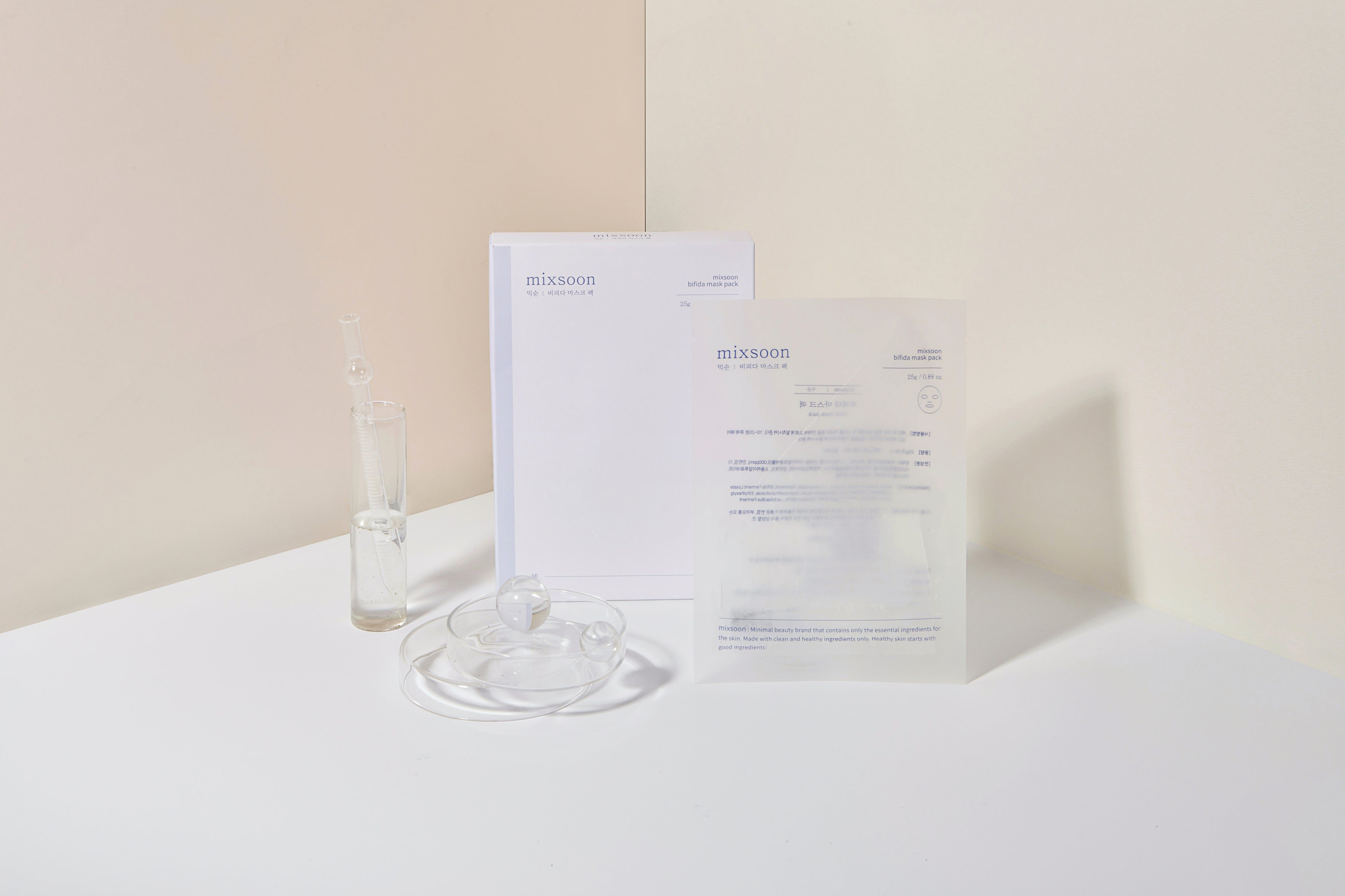 Verpakking en accessoires. Glazen flesje met vloeistof, bekertje, masker en stapel papier.