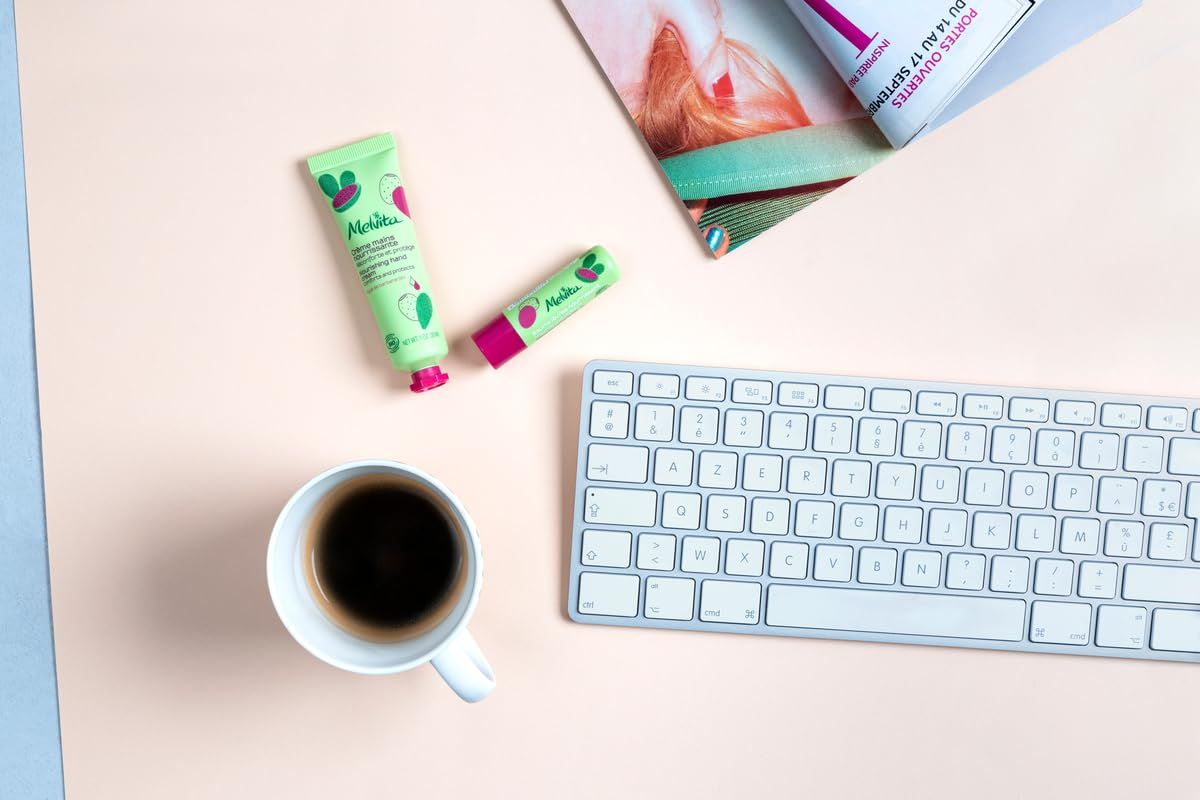 Bureau-scène met toetsenbord, koffiekopje en cosmetische producten.