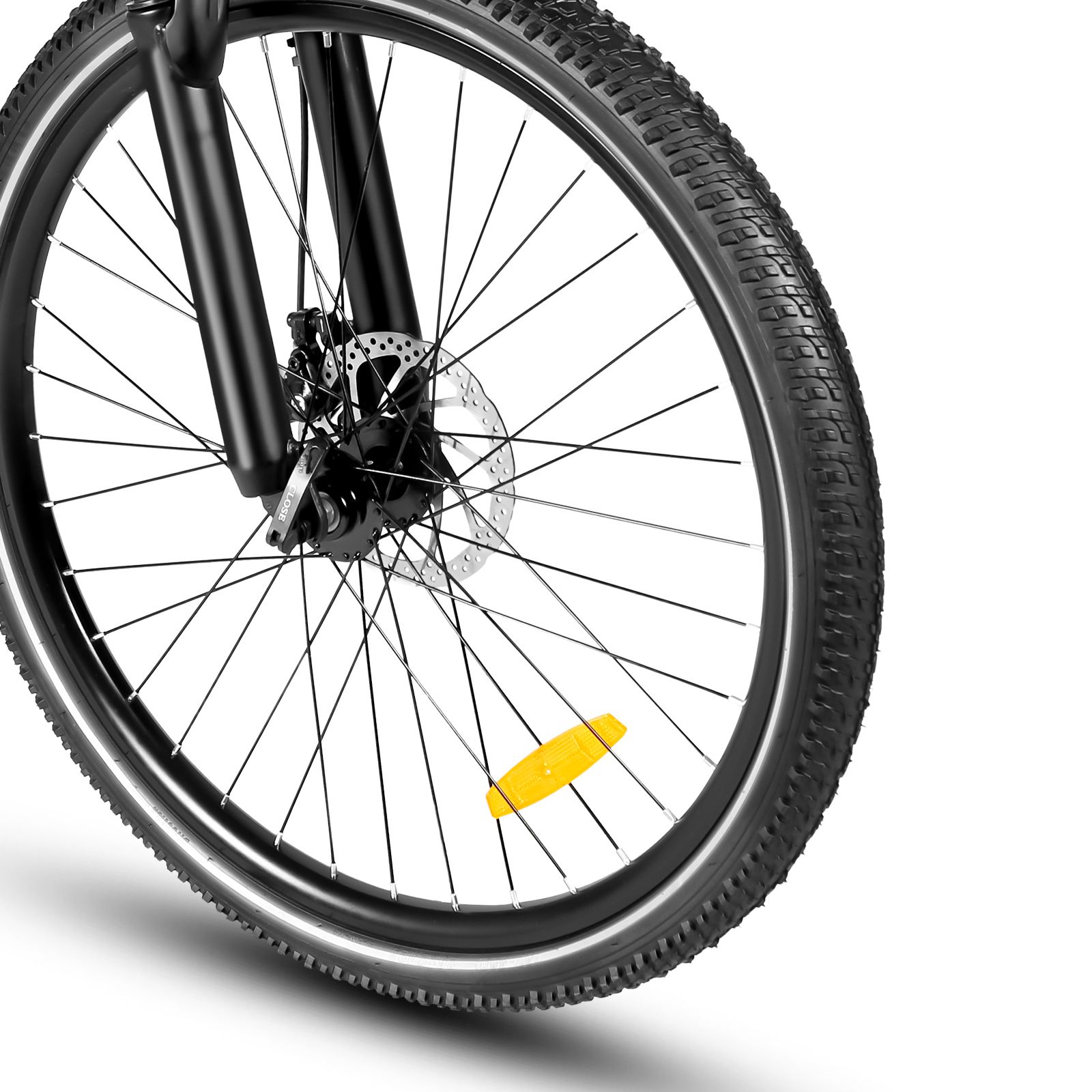 Gros plan de la roue avant d'un vélo électrique. Pneu noir, frein à disque, réflecteur jaune.