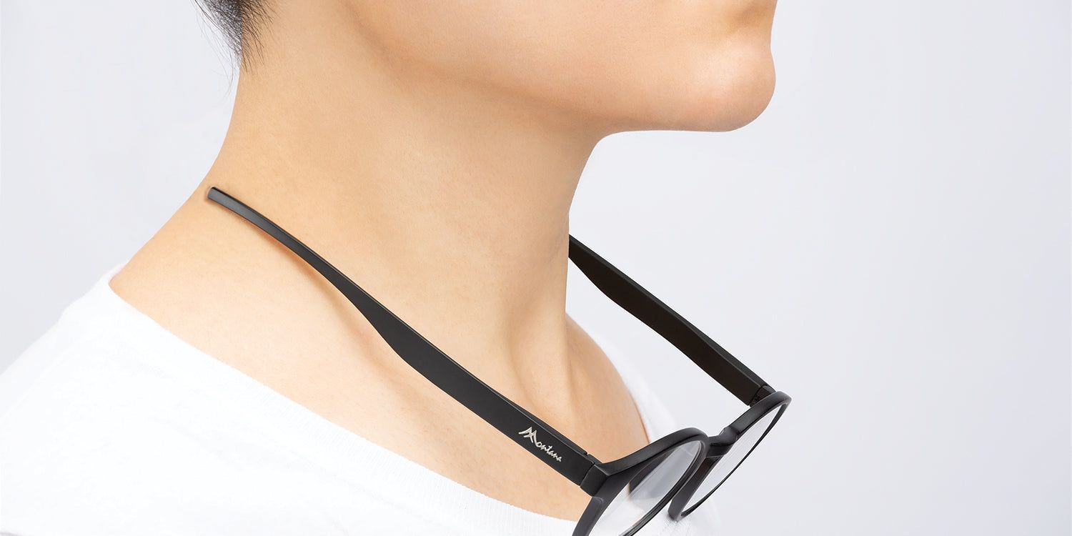 Une personne porte des lunettes noires autour du cou. Les lunettes sont attachées à la nuque.