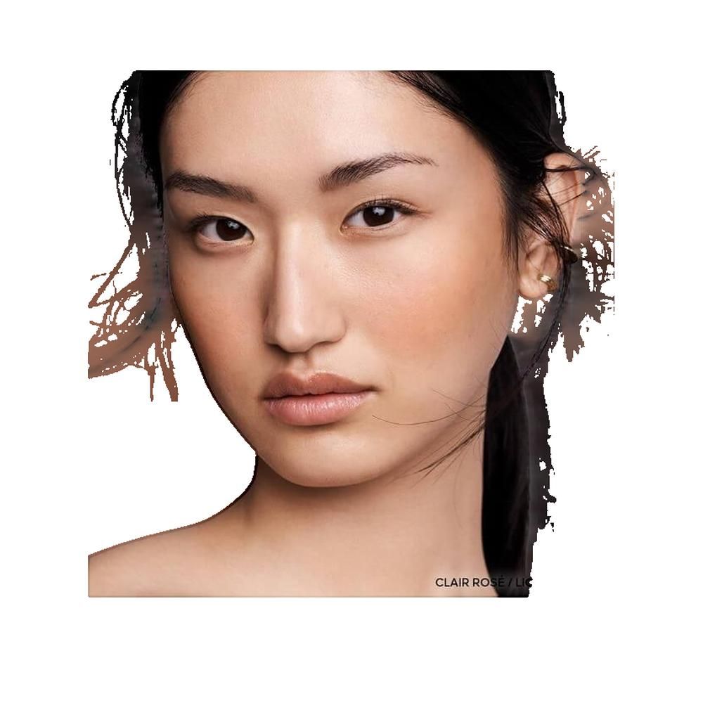 Portrait d'une femme à la peau bronzée. Une touche de blush est visible sur la joue droite.