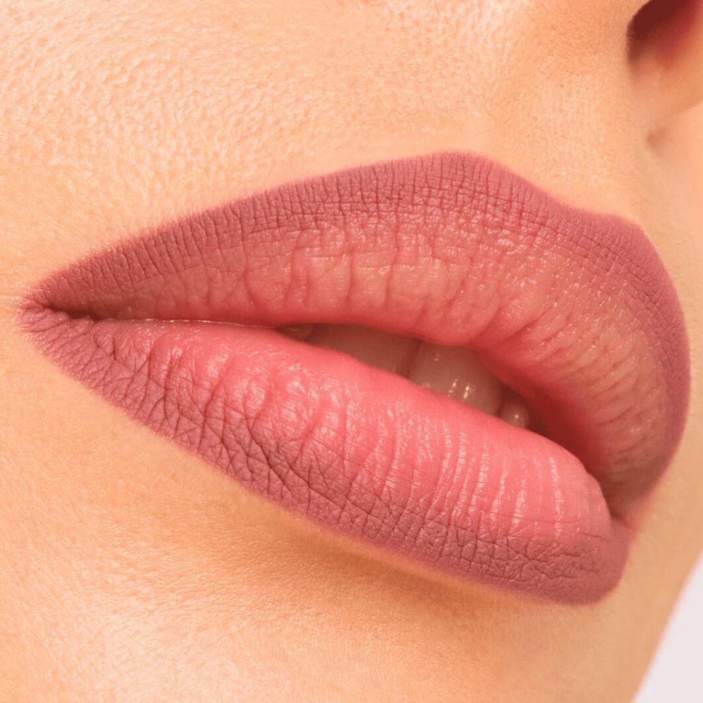 Close-up van lippen met roze lippenstift. De lippen zijn vol en glad.