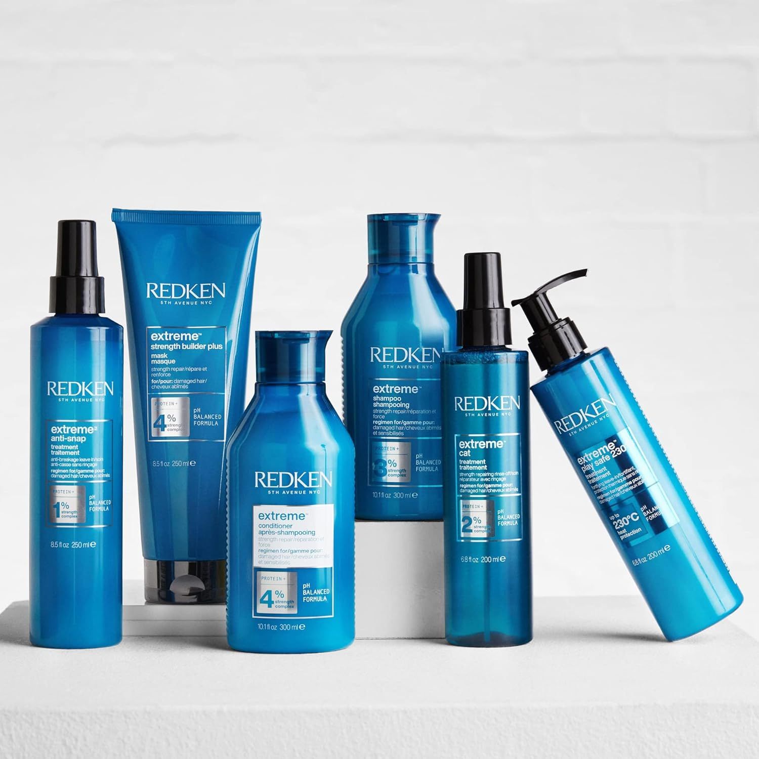 Verschillende blauwe haarproducten op een wit oppervlak. Bevatten productnamen en logo's.