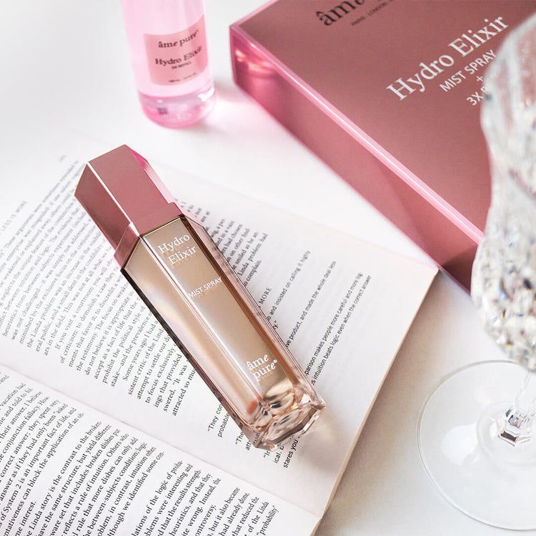 Spray âme pure Hydro Elixir sur un livre ouvert.