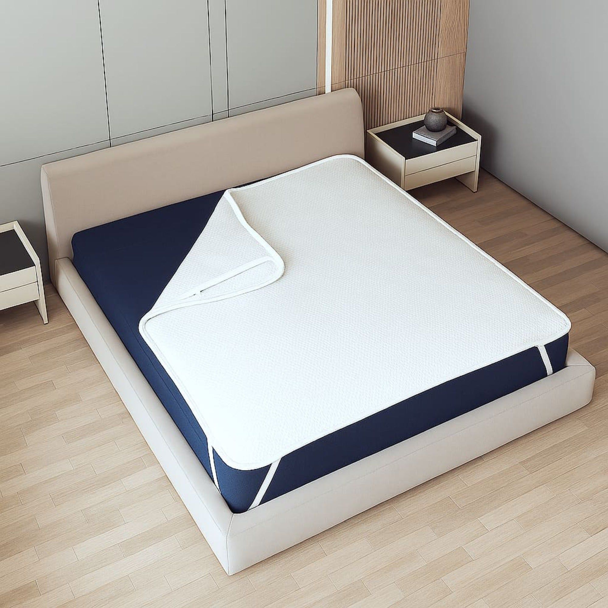 Witte matrasbeschermer op een donkerblauwe matras, met zichtbare elastieken.