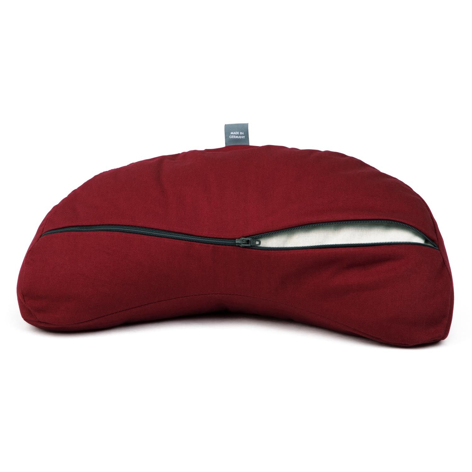 Coussin de méditation bordeaux en demi-lune, fermeture éclair ouverte révélant la housse blanche.