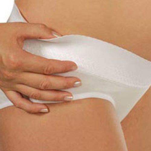Witte zwangerschapsbroek. Een hand raakt de broek. Close-up.