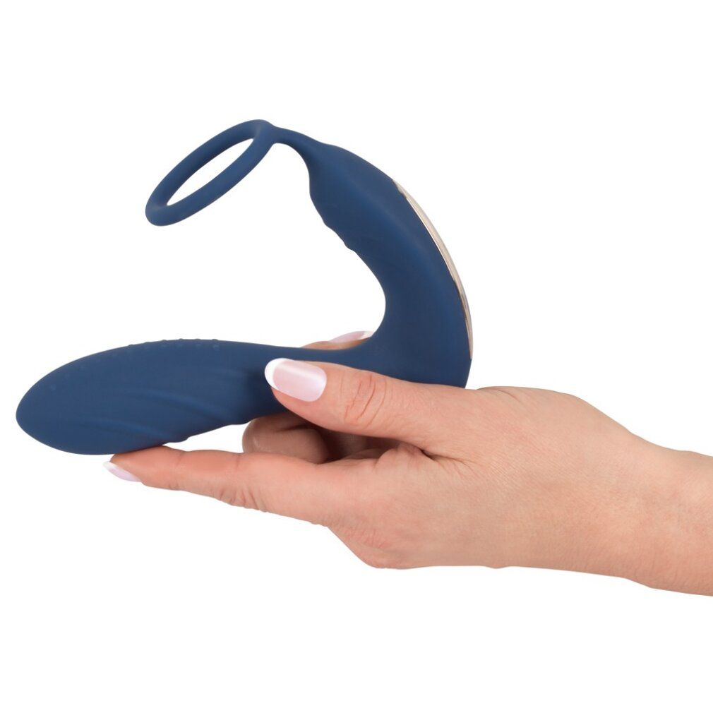 Plug anal bleu avec anneau pénien et stimulateur périnéal, tenu dans une main. Forme incurvée.