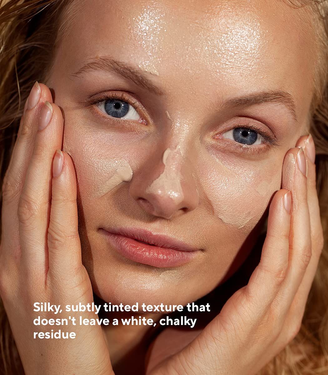 Femme avec crème solaire sur le visage. Texte : Texture soyeuse, légèrement teintée, ne laissant pas de résidu blanc et crayeux.