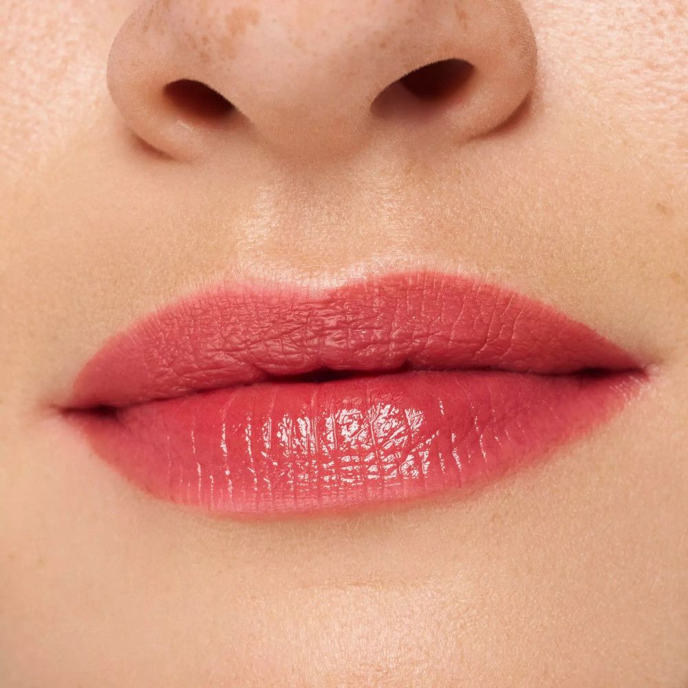 Gros plan sur des lèvres avec un Lip Tint rose. Les lèvres sont brillantes et de couleur rose.