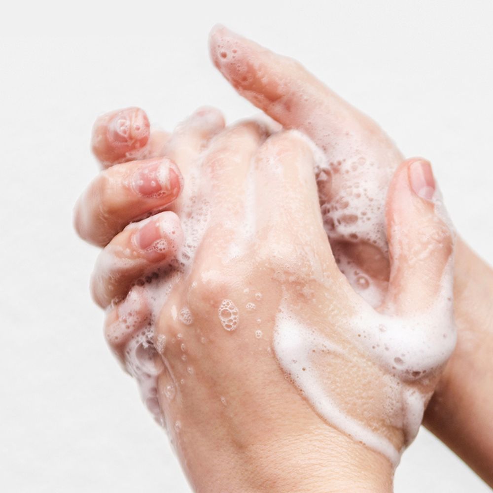 Mains couvertes de mousse de savon. Gros plan, peau claire. Savon avec bulles. Mains qui se frottent.