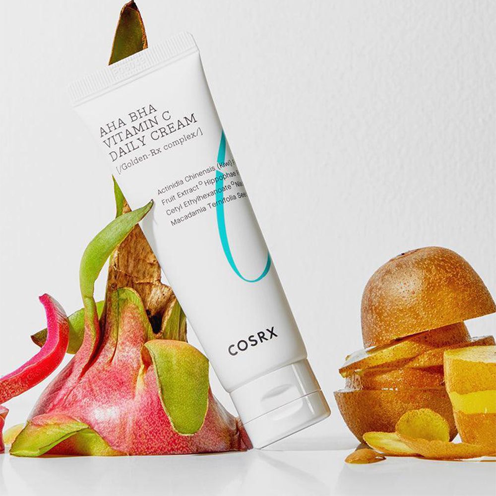 Tube COSRX AHA BHA Vitamin C Daily Cream entouré de fruits du dragon et de tranches de kiwi.