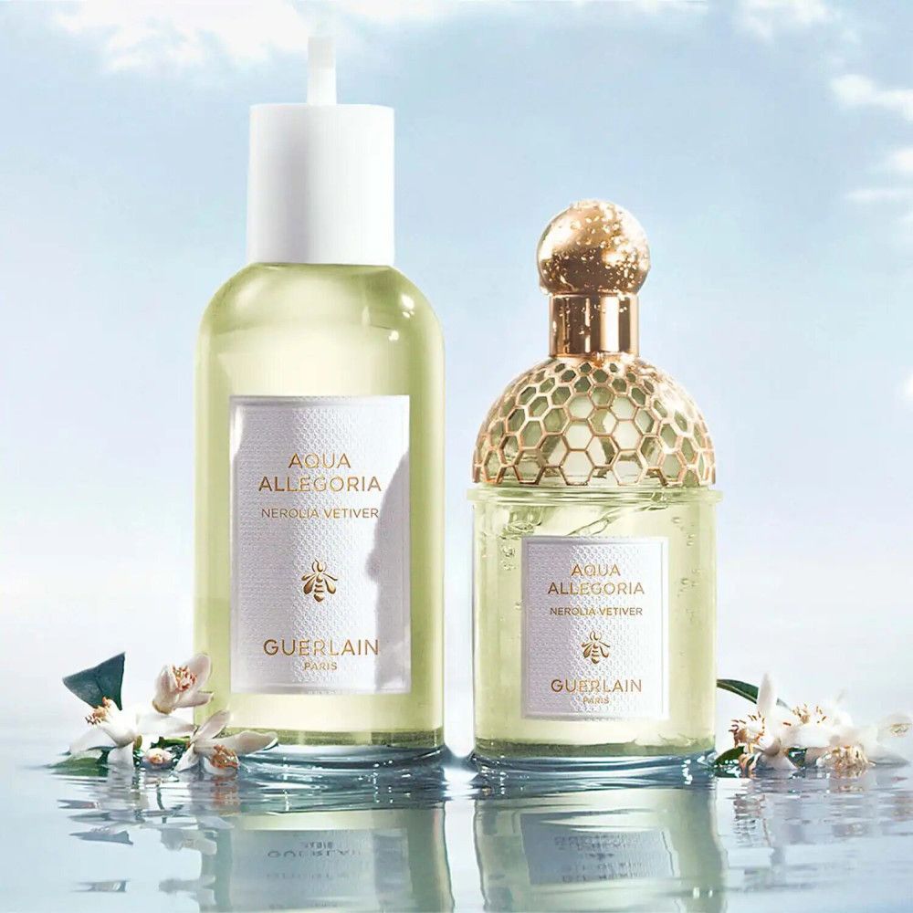 Deux flacons de parfum, un avec vaporisateur, un avec bouchon doré. Étiquettes avec texte : Aqua Allegoria Nerolia Vetiver, Guerlain.