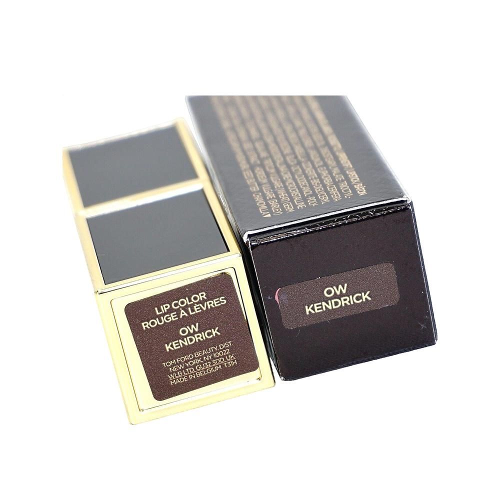 Étui de rouge à lèvres doré ouvert et emballage noir. 'OW Kendrick' est écrit sur l'emballage.