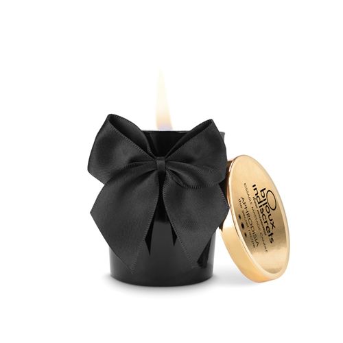 Bougie noire avec nœud et couvercle doré. Inscription sur le couvercle. Flamme allumée. Bijoux Indiscrets.