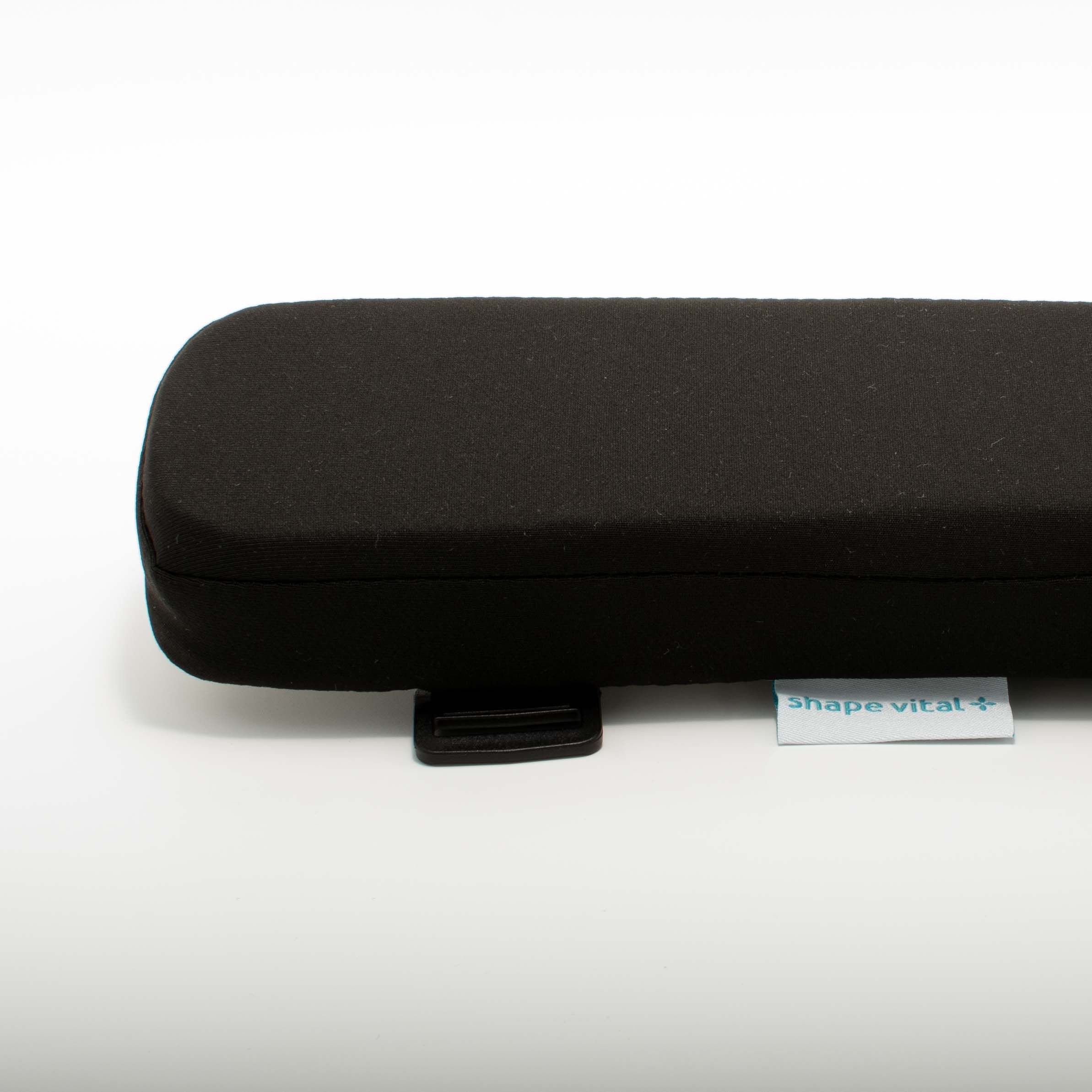 Zwart armleuningkussen met afgeronde hoeken. Klein label met 'shape vital+'. Zwarte bevestigingsclip.